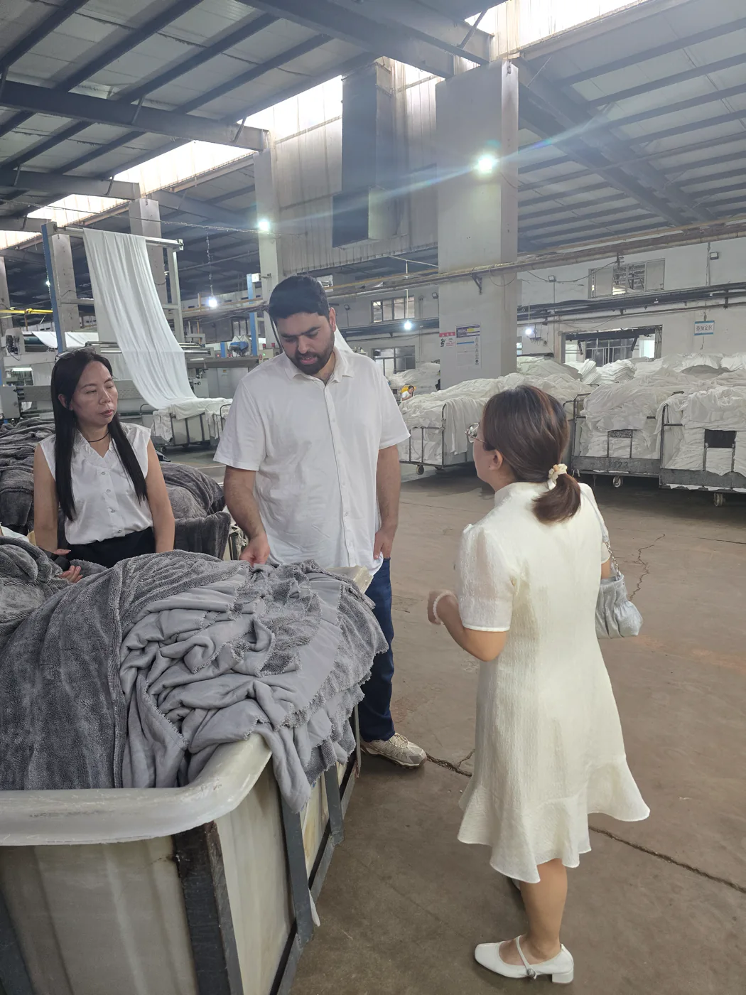 Nexus representative reviewing textile material beside production machinery