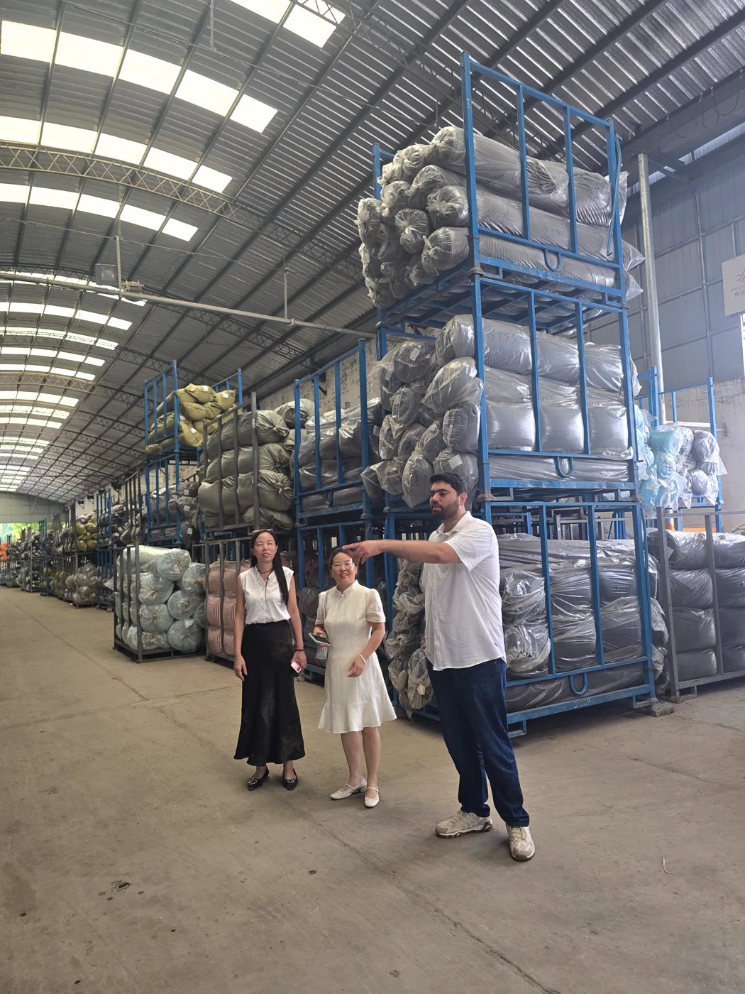 Nexus representative reviewing stored production materials inside a factory warehouse